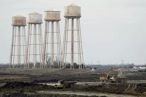 Workers prepare the site of a $4 billion Panasonic EV battery plant Thursday, March 30, 2023, near DeSoto, Kan. Economic incentives offered by Kansas state and local governments beat out those offered by neighboring Oklahoma to help lure the project to the site on land formerly occupied by an Army ammunition plant. (AP Photo/Charlie Riedel)