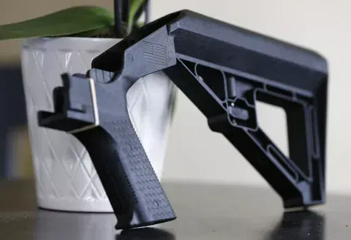 In this March 15, 2019, file photo, a bump stock is displayed in Harrisonburg, Va. A legal challenge to the Trump administration’s ban on bump stocks — devices attached to semiautomatic firearms so that a shooter can fire multiple rounds with a single trigger pull — was revived Thursday, June 23, 2022 by a federal appeals court. (AP Photo/Steve Helber, File)