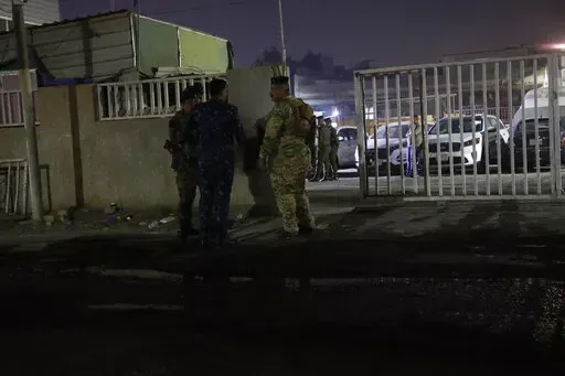Iraqi security forces gather outside a morgue of Sheikh Zayed Hospital in Baghdad, Monday, Nov. 7, 2022. Assailants shot dead an American aid worker in Baghdad on Monday in a rare killing of a foreigner in the Iraqi capital in recent years, two police officials said. (AP Photo/Hadi Mizban)