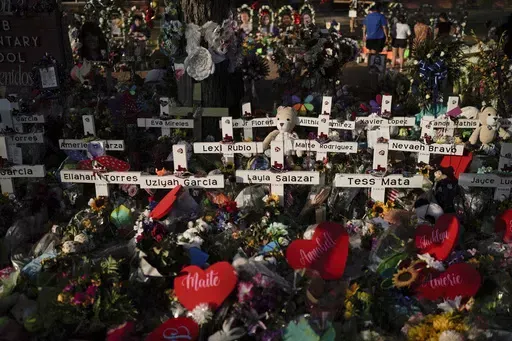 Flowers are piled around crosses with the names of the victims killed in a school shooting as people visit a memorial at Robb Elementary School to pay their respects May 31, 2022, in Uvalde, Texas. For the first time since the Uvalde school massacre, Texas Republican lawmakers on Tuesday, April 18, 2023, allowed proposals for stricter gun laws to get a hearing in the state Capitol — even though new restrictions have almost no chance of passing. (AP Photo/Jae C. Hong, File)