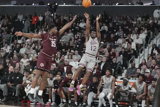 Mississippi State guard Josh Hubbard (12) shoots a three-point shot while Texas A&M forward Henry Coleman III (15) attempts to block during the second half of an NCAA college basketball game, Tuesday, Feb. 18, 2025, in Starkville, Miss. (AP Photo/Rogelio V. Solis)