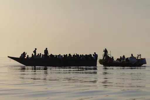 Migrants, left, are being rescued by volunteers of the Ocean Viking, a migrant search and rescue ship run by NGOs SOS Mediterranee and the International Federation of Red Cross (IFCR),  Saturday, Aug. 27, 2022, some 26 nautical miles south of the Italian Lampedusa island in the Mediterranean sea. 87 survivors, including 3 women, 25 minors were rescued in the rescue operation. (AP Photo/Jeremias Gonzalez)