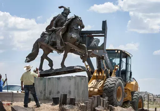 Rio Arriba County workers remove the bronze statue of Spanish conquerer Juan de Onate from its pedestal in front of a cultural center in Alcalde, N.M., June 15, 2020. A settlement has been reached in a civil lawsuit seeking damages from a 23-year-old man and his parents in the shooting of a Native American activist in northern New Mexico amid confrontations about the statue and aborted plans to reinstall it in public. The settlement was disclosed Tuesday, May 7, 2024, in court documents. (Eddie 