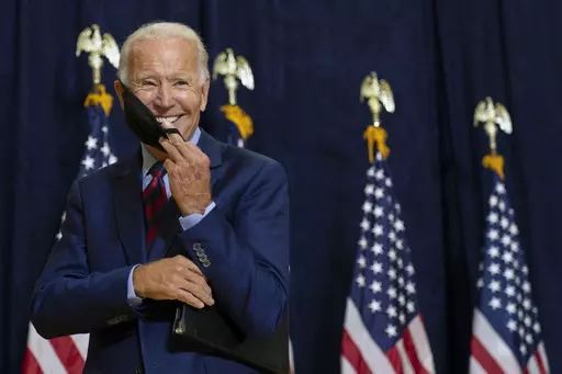 Democratic presidential candidate former Vice President Joe Biden smiles as he puts on his face mask after speaking to media in Wilmington, Del., on Sept. 4, 2020. (AP Photo/Carolyn Kaster, File)