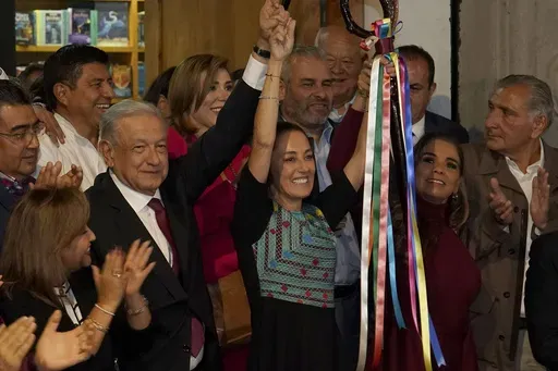 Mexican President Andres Manuel Lopez Obrador raises the hand of Claudia Sheinbaum, the ruling party's presidential candidate, during a ceremony to give her the party's command staff in Mexico City, Sept. 7, 2023. (AP Photo/Marco Ugarte, File)
