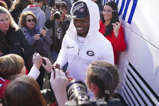 Georgia linebacker Nakobe Dean is greeted by a large crowd of fans as he and his teammates return to the Georgia campus, Tuesday, Jan. 11, 2022, in Athens, Ga., after defeating Alabama in the College Football Championship NCAA college football game. (AP Photo/John Bazemore)