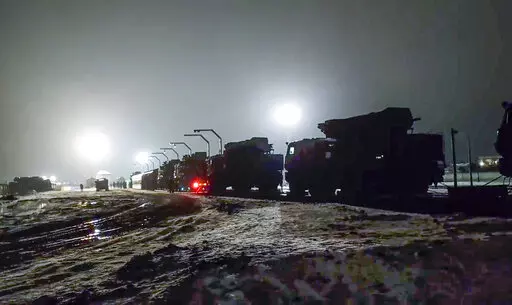 In this photo taken from video provided by the Russian Defense Ministry Press Service on Saturday, Jan. 29, 2022, Russian military vehicles prepares to drive off a railway platforms after arrival in Belarus. In a move that further beefs up forces near Ukraine, Russia has sent an unspecified number of troops from the country's far east to its ally Belarus, which shares a border with Ukraine, for major war games next month. (Russian Defense Ministry Press Service via AP)