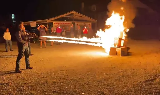 In this frame grab from video provided by Debbie McFarland, state Sen. Bill Eigel torches a pile of cardboard boxes at a “Freedom Fest” event in Defiance, Mo., Sept. 15, 2023. Eigel is a Republican candidate for Missouri governor. After video of Eigel's use of the flamethrower gained attention, Eigel said he'd burn objectionable books if that's what it took to keep them away from children. (Debbie McFarland via AP)
