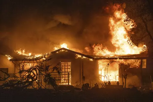 A house burns on Platina Road at the Zogg Fire near Ono, Calif., on Sept. 27, 2020. A Northern California judge on Wednesday, May 31, 2023, dismissed all charges against Pacific Gas & Electric for its role in the 2020 fatal wildfire sparked by its equipment that destroyed hundreds of homes and killed four people, including an 8-year-old child. (AP Photo/Ethan Swope, File)