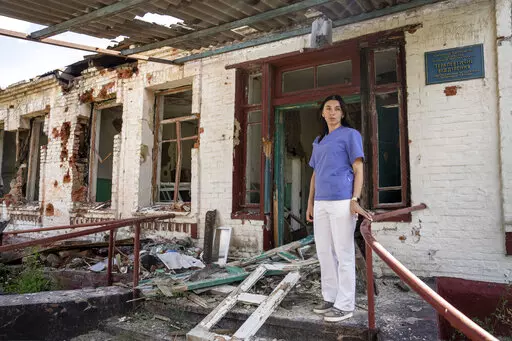Dr. Ilona Butova stands in front of the therapy department which was destroyed after a Russia attack on the hospital in Zolochiv, Kharkiv region, Ukraine, Sunday, July 31, 2022. Ukraine's health care system already was struggling due to corruption, mismanagement and the COVID-19 pandemic. But the war with Russia has only made things worse, with facilities damaged or destroyed, medical staff relocating to safer places and many drugs unavailable or in short supply. (AP Photo/Evgeniy Maloletka)