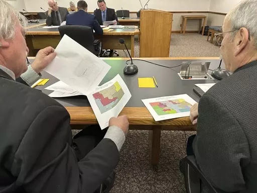 North Dakota state Rep. Robin Weisz, at left, and state Sen. Jerry Klein, both Republicans, inspect alternative maps proposed by the Turtle Mountain Band of Chippewa Indians and the Spirit Lake Tribe, on Tuesday, Dec. 5, 2023, during a meeting of a top legislative panel at the state Capitol in Bismarck, N.D. The 8th U.S. Circuit Court of Appeals denied a request on Friday, Dec. 15, to delay a federal judge's decision that North Dakota's legislative map violates the Voting Rights Act in diluting 