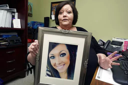 CORRECTS TO DELETE THE MIDDLE NAME AND SAY HARBOUR WAS A VICTIM - Denise Spears holds a portrait of her late step-daughter Marsha Harbour, in her Meridian, Miss., office, Tuesday, April 12, 2022. Although Marsha's husband, Truitt Pace, admitted killing his wife, he was free on bond while court proceedings were partially held up because the Mississippi Medical Examiner's Office autopsy report was delayed for a year, and the trial got held up further because of the pandemic and other factors. Harb
