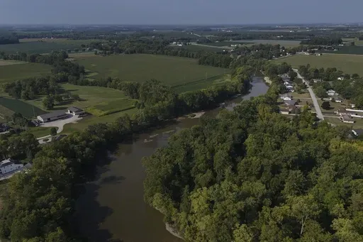 Water flows down the Sandusky River between farms, Aug. 26, 2024, in Fremont, Ohio. (AP Photo/Joshua A. Bickel, File)