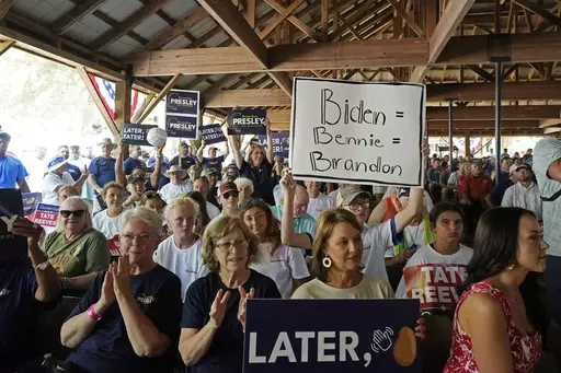 A person holds a sign that links President Joe Biden to Democratic U.S. Rep. Bennie Thompson of Mississippi and Brandon Presley, the Democratic nominee for Mississippi governor at the Neshoba County Fair near Philadelphia, Miss., on July 27, 2023. As Republican Gov. Tate Reeves seeks a second term, he faces Presley and independent candidate Gwendolyn Gray in the Nov. 7, 2023, general election. Reeves often says a vote for Presley equates to a vote for Biden and Thompson. (AP Photo/Rogelio V. Sol