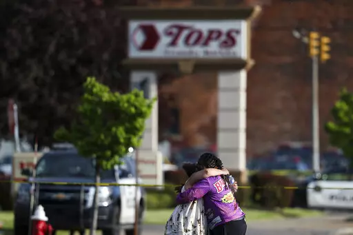 People hug outside the scene after a shooting at a supermarket on Saturday, May 14, 2022, in Buffalo, N.Y. (AP Photo/Joshua Bessex)