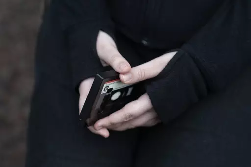A teenager holds her phone as she sits for a portrait near her home in Illinois, on Friday, March 24, 2023. The U.S. Surgeon General is warning there is not enough evidence to show that social media is safe for young people — and is calling on tech companies, parents and caregivers to take "immediate action to protect kids now." (AP Photo Erin Hooley, File)