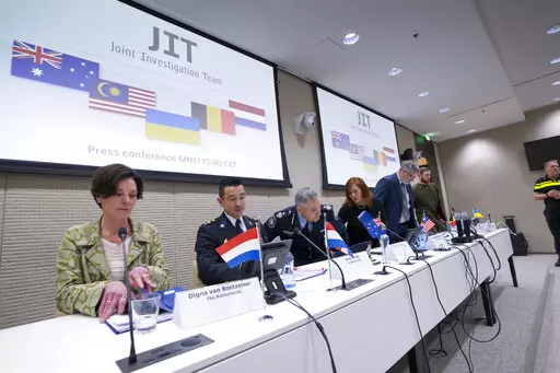 Digna van Boetzelaer, the Netherlands, Andy Kraag, the Netherlands, David McLean, Australia, Asha Hoe Soo Lian, Malaysia, Eric van der Sypt, Belgium, and Oleksandr Bannyk, Ukraine, take their seats for the Joint Investigation Team (JIT) news conference in The Hague, Netherlands, Wednesday, Feb. 8, 2023, on the results of the ongoing investigation into other parties involved in the downing of flight MH17 on 17 July 2014. The JIT investigated the crew of the Buk-TELAR, a Russian made rocket launch