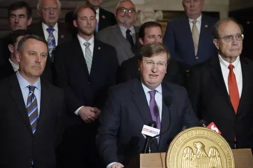 Mississippi Republican Gov. Tate Reeves, center, stands with House Speaker Jason White, R-West, left, and Republican Lt. Gov. Delbert Hosemann, right, as well as the legislators behind him, as he praises the passing of a state incentives package for a Mississippi factory that will manufacture batteries for electric vehicles — a project that promises 2,000 jobs, following a special session of the Mississippi Legislature, Thursday, Jan. 18, 2024, at the Mississippi Capitol in Jackson, Miss. (AP 