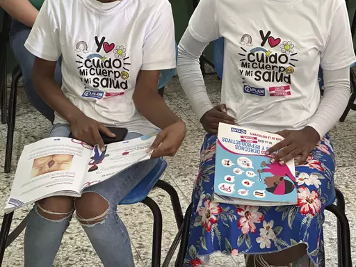 Teenage club members wear shirts that reads in Spanish "I take care of my body and my heath" at a session on sex education at a school on the weekend in Azua, Dominican Republic, Saturday, Dec. 9, 2023. To help girls prevent unplanned pregnancies in a country where abortion is illegal, activists have developed “teenage clubs,” where adolescents learn about sexual and reproductive rights, self-esteem, gender violence, finances and other topics. (AP Photo/Maria Hernandez)