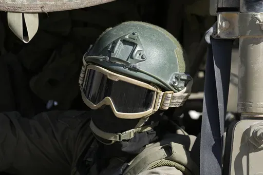 An Israeli soldier drives in a vehicle on the Israel-Gaza border, as seen from southern Israel, Friday, Oct. 18, 2024. (AP Photo/Tsafrir Abayov)