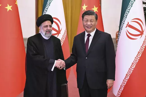 In this photo released by Xinhua News Agency, Visiting Iranian President Ebrahim Raisi, left, shakes hands with Chinese President Xi Jinping before their meeting at the Great Hall of the People in Beijing, Feb. 14, 2023. (Yan Yan/Xinhua via AP, File)