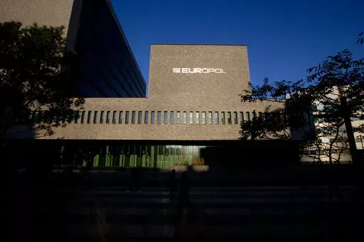 FILE- This Wednesday, Oct. 10, 2018, file photo shows the sun bouncing off the Europol headquarters in The Hague, Netherlands. Europol says law enforcement authorities in six different countries have joined forces to take down a “super cartel” of drugs traffickers controlling about one third of the cocaine trade in Europe. (AP Photo/Peter Dejong, File)