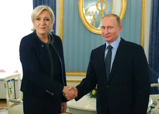 Russian President Vladimir Putin, right, shakes hands with French far-right presidential candidate Marine Le Pen, in the Kremlin in Moscow, Russia, Friday, March 24, 2017. France is thousands of miles from Ukraine, but what happens in French voting stations this month could have repercussions in Ukrainian battlefields. Nationalist candidate Marine Le Pen wants to halt arms supplies to Ukraine, improve Western ties with Russia and weaken the EU and NATO, which would undermine long-held Western al