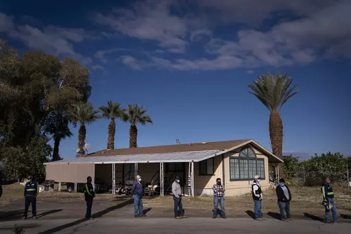 Farm workers wait in line at Tudor Ranch in Mecca, Calif., Jan. 21, 2021. Every year, heat kills more people than floods, hurricanes and tornadoes combined, and experts warn that extreme heat will become more intense, frequent and lethal with climate change. (AP Photo/Jae C. Hong, File)