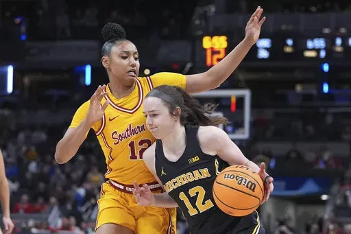 Michigan guard Syla Swords (12) drives on Southern California guard JuJu Watkins (12) during the second half of an NCAA college basketball game in the semifinals of the Big Ten Conference tournament in Indianapolis, Saturday, March 8, 2025. (AP Photo/Michael Conroy)