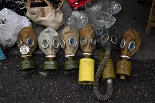 Soviet-era gas masks are for sale at a flea market in Kyiv, Ukraine, Saturday, July 8, 2023. The Pochaina neighborhood in the Ukrainian capital comes alive every weekend as hundreds of people flock to its famous flea market, looking for finds. Antique-hunters, collectors and many others look over seemingly endless rows of trinkets and time-worn wares. It's a dizzying array that includes Soviet-era relics such as decorative medals, ceramics with communist leaders' portraits, Cold War-era gas mask