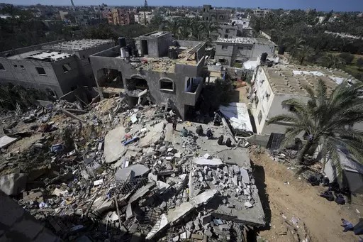 Palestinians look at destruction after an Israeli airstrike on a residential building of the Ganan family in Deir al Balah, Gaza Strip, Thursday, March 7, 2024. (AP Photo/Adel Hana)