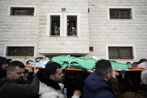 Palestinian mourners carry the body of Muhammad Jalamneh, draped in the Hamas militant group flag, during his funeral after he was killed in an Israeli military raid at Ibn Sina Hospital in the West Bank town of Jenin, Tuesday, Jan. 30, 2024. Armed Israeli undercover forces disguised as women and medical workers stormed the hospital on Tuesday, killing three Palestinian militants. The Palestinian Health Ministry condemned the incursion on a hospital, where the military said the militants were hi