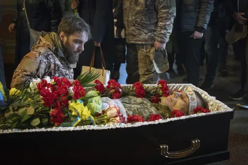 A serviceman pays his last respects to late Ukrainian soldier Vasyl Ratushnyy, 28, during the funeral ceremony in St. Michael Cathedral in Kyiv, Ukraine, Wednesday, March 5, 2025. (AP Photo/Efrem Lukatsky)