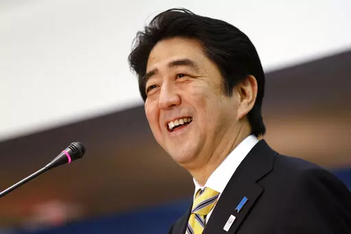 Japanese Prime Minister Shinzo Abe laughs while speaking at the Center for Strategic International Studies in Washington on Feb. 22, 2013. The assassination of former Japanese Prime Shinzo Abe has unearthed long-suspected, little-talked-of links between him and a religious group that started in South Korea but has spread its influence around the world. (AP Photo/Jacquelyn Martin, File)