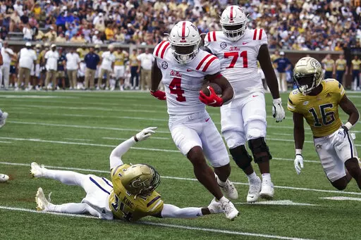 Mississippi running back Quinshon Judkins (4) gets past Georgia Tech defensive back Jaylon King (14) as he runs for a touchdown in the first half of an NCAA college football game, Saturday, Sept. 17, 2022, in Atlanta. (AP Photo/John Bazemore)