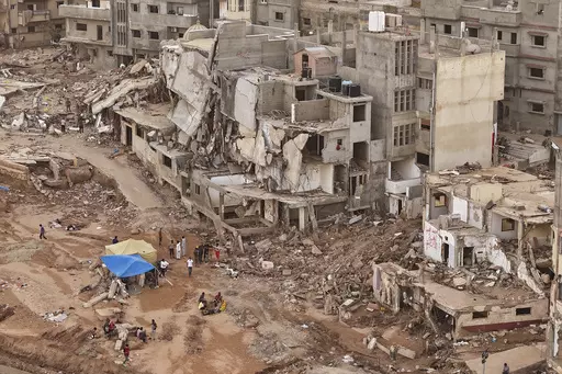 Rescuers and relatives of victims set up tents in front of collapsed buildings in Derna, Libya, Monday, Sept. 18, 2023. Some 11,300 people died when two dams collapsed during Mediterranean storm Daniel last week sending a wall of water gushing through the city, according to the Red Crescent aid group. A further 10,000 people are missing, and presumed dead. (AP Photo/Muhammad J. Elalwany)