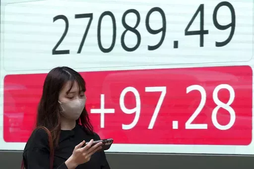 A person walks in front of an electronic stock board showing Japan's Nikkei 225 index at a securities firm Wednesday, Oct. 5, 2022, in Tokyo. Hong Kong’s share benchmark soared more than 5% on Wednesday as Asian shares tracked gains on Wall Street. (AP Photo/Eugene Hoshiko)