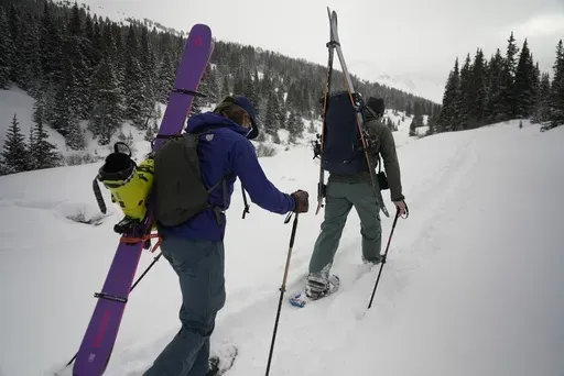 Michael Otenbaker and Joseph Burgoyne snowshoe into a backcountry ski area Wednesday, March 5, 2025, in Frisco, Colo. (AP Photo/Brittany Peterson)