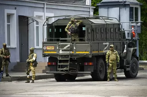 Russian soldiers guard an area as a group of foreign journalists visit in Kherson, Kherson region, south Ukraine, May 20, 2022. Russia’s military has announced that it’s withdrawing from Ukraine's southern city of Kherson and nearby areas. That would be another in a series of humiliating setbacks for Moscow’s forces in the 8-month-old war. This photo was taken during a trip organized by the Russian Ministry of Defense. (AP Photo, File)