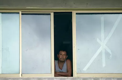 A man looks out of a window of a school that was used as a refuge from Hurricane Orlene in Escuinapa, Mexico, Monday, Oct. 3, 2022. Hurricane Orlene made landfall on Mexico's Pacific coast near the tourist town of Mazatlan on Monday before quickly weakening over western Mexico. (AP Photo/Fernando Llano)