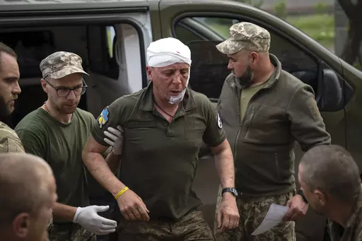 Ukrainian soldiers help their wounded fellow at a medical stabilisation point near Bakhmut, Donetsk region, Ukraine, Wednesday, May 24, 2023. (AP Photo/Efrem Lukatsky)