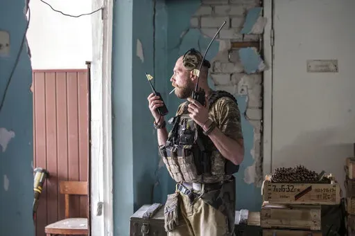 A Ukrainian soldier holds radios during heavy fighting on the front line in Severodonetsk, the Luhansk region, Ukraine, Wednesday, June 8, 2022. (AP Photo/Oleksandr Ratushniak)