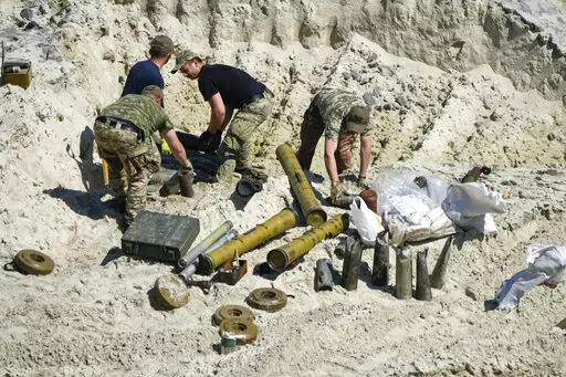 Ukrainian servicemen prepare to detonate unexploded Russian ammunition in the outskirts of Kyiv, Ukraine, Wednesday, June 1, 2022. (AP Photo/Natacha Pisarenko)