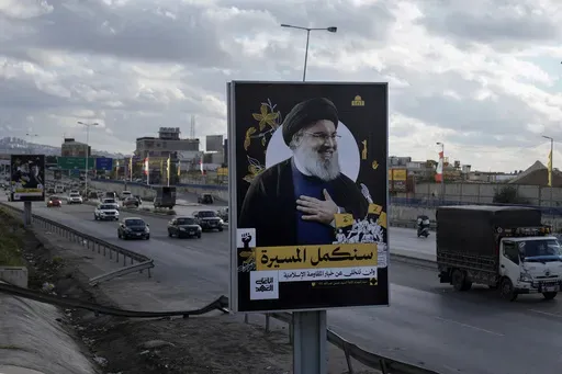 People drive past a billboard with a picture of the late Lebanon's Hezbollah leader Sayyed Hassan Nasrallah displayed on Beirut airport highway, Lebanon, Friday, Feb. 21, 2025. (AP Photo/Bilal Hussein)