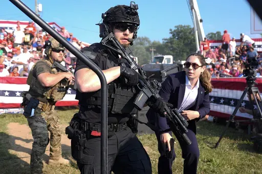 U.S. Secret Service agents respond as Republican presidential candidate former President Donald Trump is surrounded on stage by U.S. Secret Service agents at a campaign rally, July 13, 2024, in Butler, Pa. (AP Photo/Evan Vucci, File)