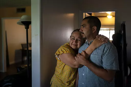 Ana Sandoval, mother of Eyvin Hernandez, a Los Angeles attorney who has been detained for five months in Venezuela, hugs her son Henry Martinez, Hernandez's half-brother, while posing for photos in Compton, Calif., Monday, Aug. 29, 2022. The Los Angeles attorney detained for five months in Venezuela is pleading for help from the Biden administration, saying in a secretly recorded jailhouse message that he feels forgotten by the U.S. government as he faces criminal charges at the hands of one of 