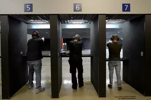 Gun owners fire their pistols at an indoor shooting range during a qualification course to renew their carry concealed handgun permits, July 1, 2022, at the Placer Sporting Club in Roseville, Calif. A California law that bans people from carrying firearms in most public places is taking effect on New Year's Day, even as a court case continues to challenge the law. (AP Photo/Rich Pedroncelli, File)