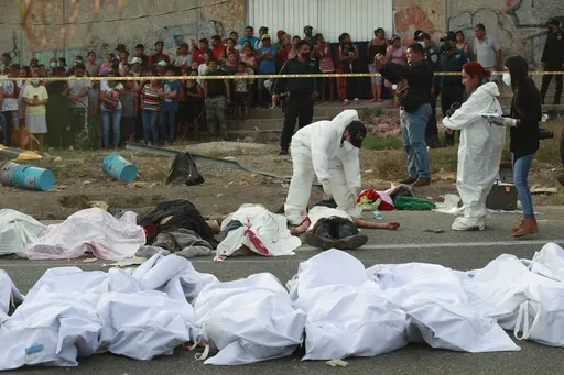 Bodies in bodybags are placed on the side of the road after a deadly semi-trailer truck crash in Tuxtla Gutierrez, Chiapas state, Mexico, Dec. 9, 2021. (AP Photo, File)