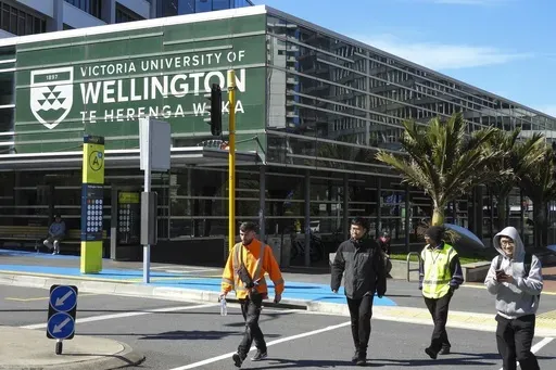 People walk past the name of Victoria University of Wellington, written in English and Maori languages as New Zealand celebrates its annual Maori language week in Wellington, New Zealand, Wednesday, Sept. 18, 2024. (AP Photo/Charlotte GrahamMcLay)