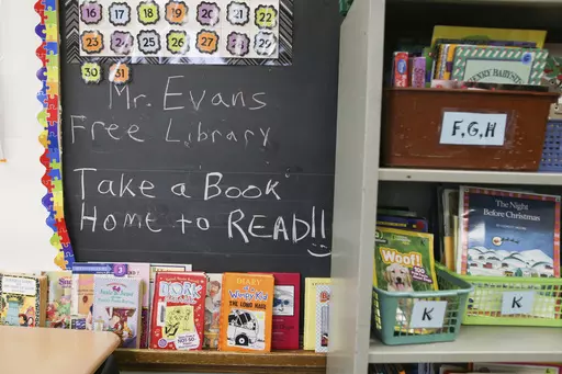 Books are displayed on a free library shelf inside the classroom of Richard Evans, a teacher at Hyde Park Elementary School, on Thursday, Oct. 20, 2022, in Niagara Falls, N.Y. Stuck with distance learning as they began grade school, the kids who are now finishing elementary school were the ones most disrupted by COVID, with alarming delays in their reading ability. (AP Photo/Joshua Bessex, File)